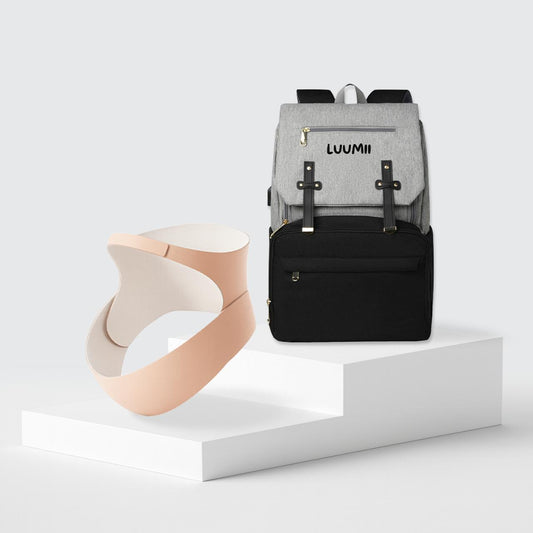 Luumii stelleveske i grå og svart farge sammen med ergonomisk støttebelte for gravide på hvitt podium