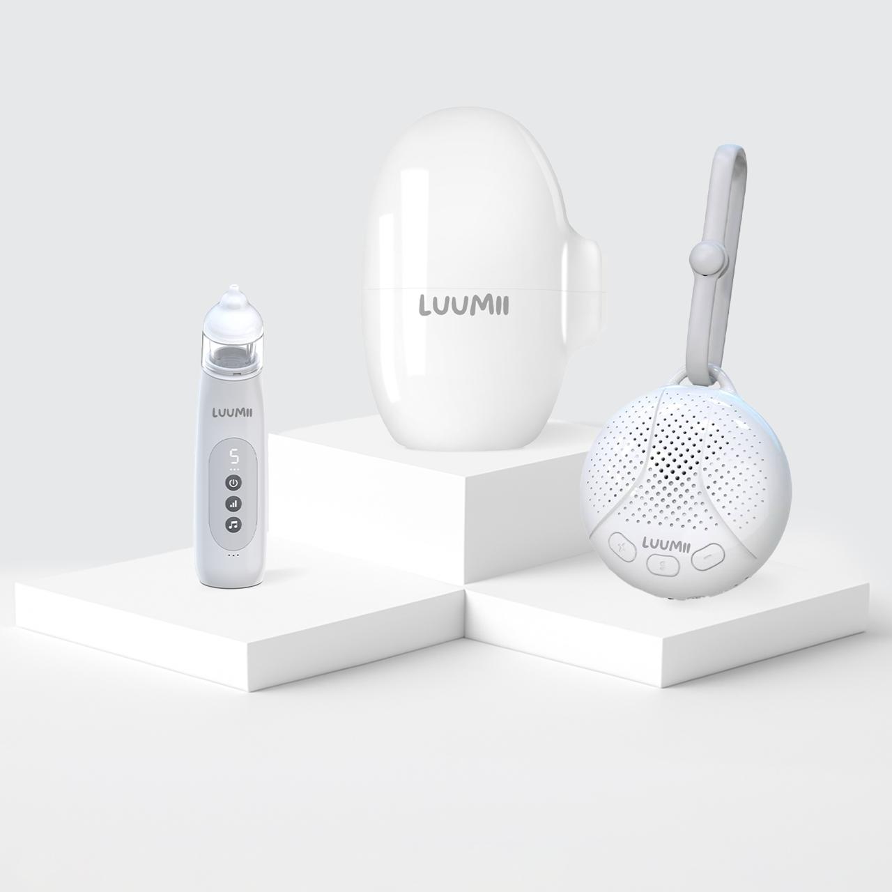 Luumii elektrisk nesesuger, bærbar white noise-maskin og Luumii Baby Rocker på hvite podiumelementer.