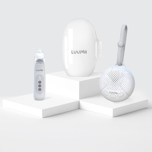 Luumii elektrisk nesesuger, bærbar white noise-maskin og Luumii Baby Rocker på hvite podiumelementer.
