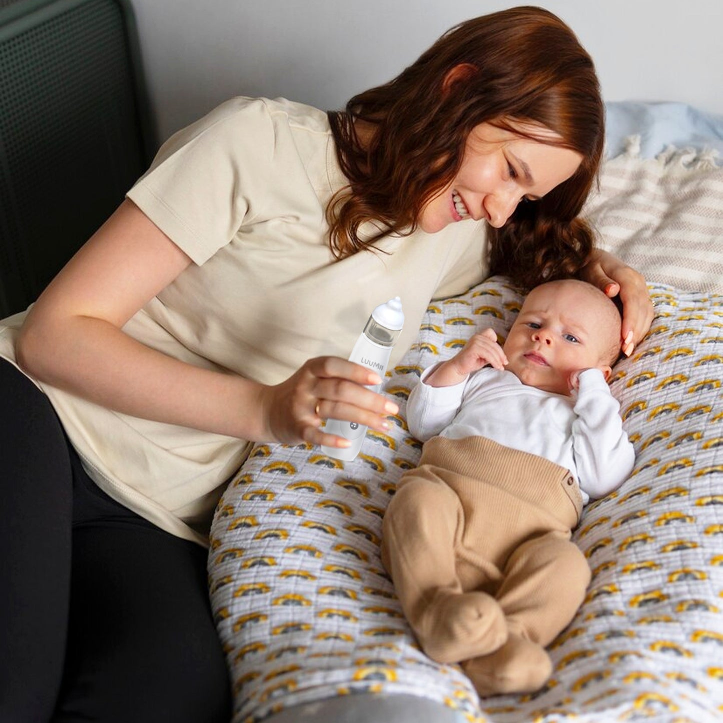 Mor som bruker Luumii BabyGo elektrisk nesesuger for å rense nesen til babyen.