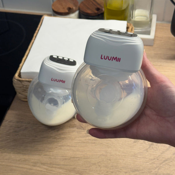 Luumii bærbar brystpumpe fylt med melk vist i bruk på kjøkkenbenk