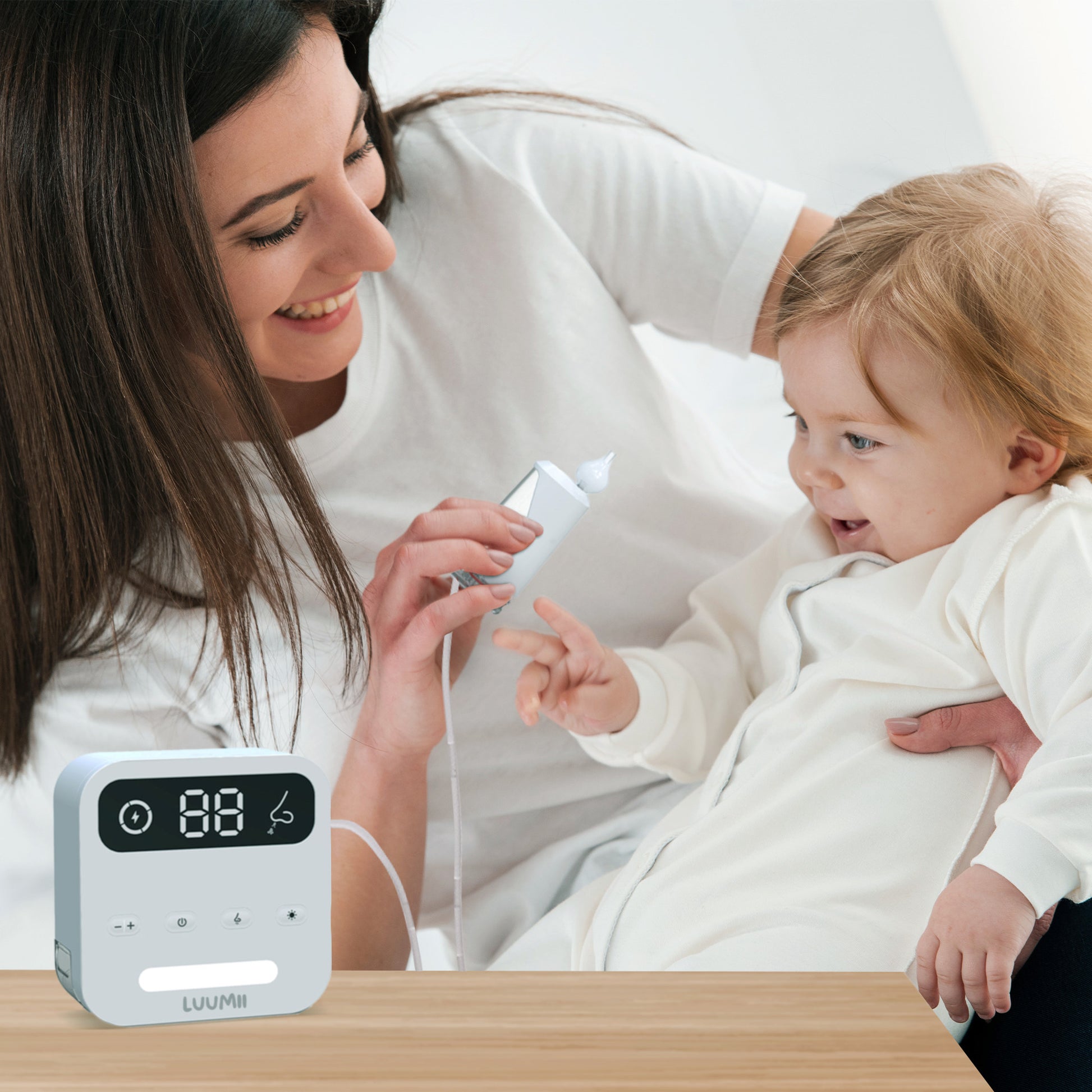 Mor bruker Luumii Desktop elektrisk nesesuger for å rense nesen til babyen på en skånsom måte.